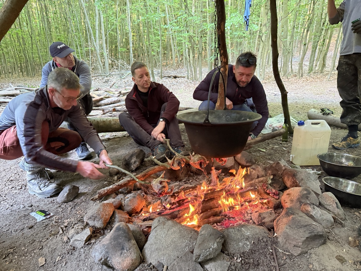 Gemeinsam kochen am Lagerfeuer beim Survival Base Camp